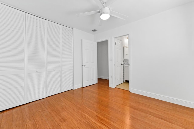 unfurnished bedroom featuring ceiling fan, a closet, ensuite bathroom, and light hardwood / wood-style floors