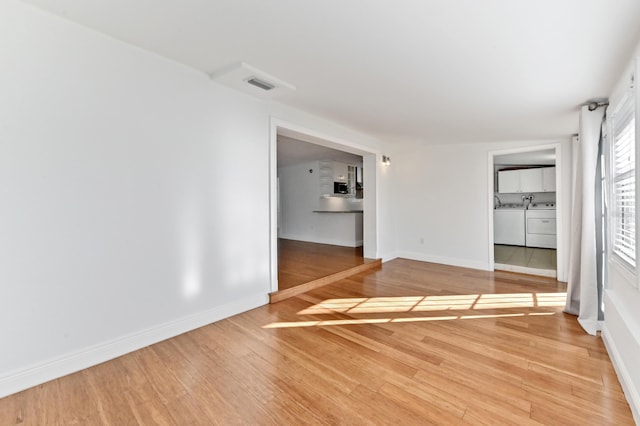 spare room featuring washer and dryer and hardwood / wood-style floors