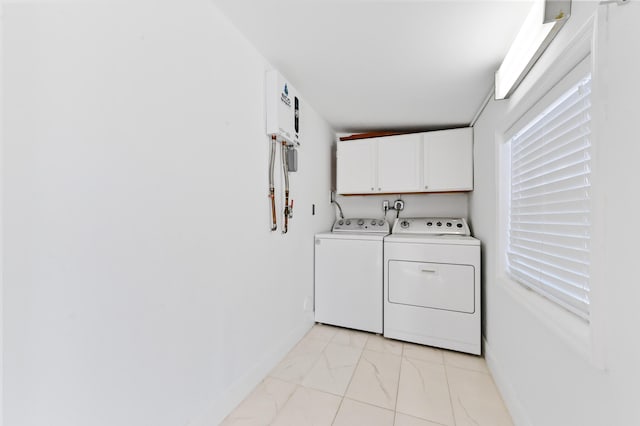 washroom with washer and dryer and cabinets