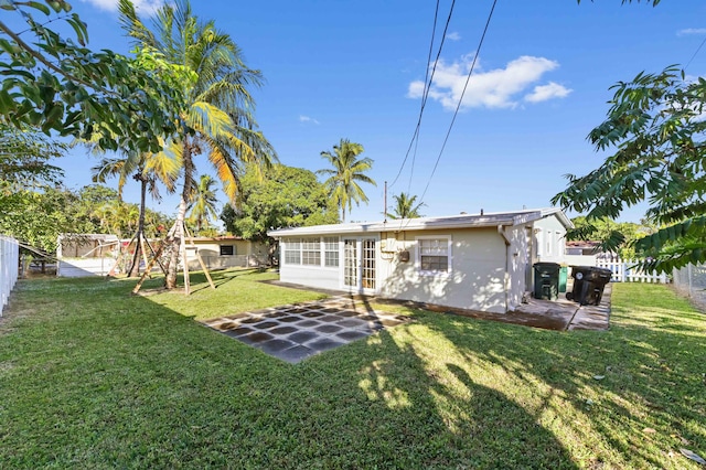 back of property featuring a playground, a patio area, and a yard