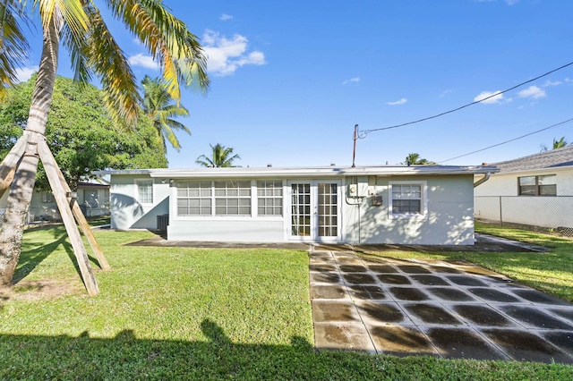 rear view of house featuring a yard, french doors, and a patio