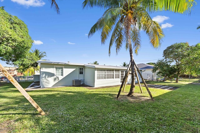 back of house with a yard and central AC