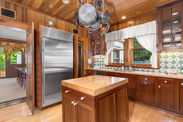 kitchen with built in fridge, wooden ceiling, and a wealth of natural light