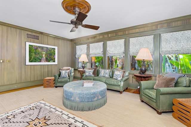 living room featuring ceiling fan, wooden walls, and light hardwood / wood-style floors