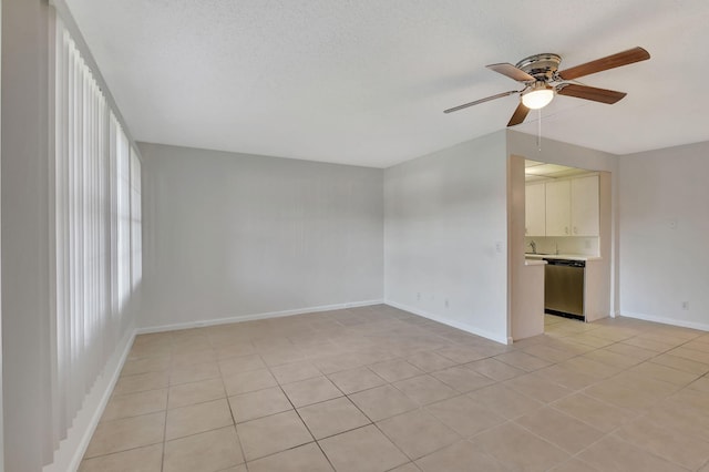 tiled empty room with ceiling fan and a textured ceiling