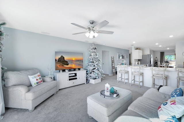 carpeted living room with ceiling fan