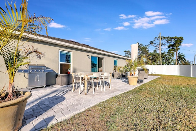 rear view of property with a lawn and a patio area