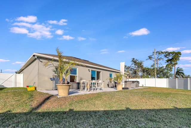 back of property featuring a lawn and a patio area