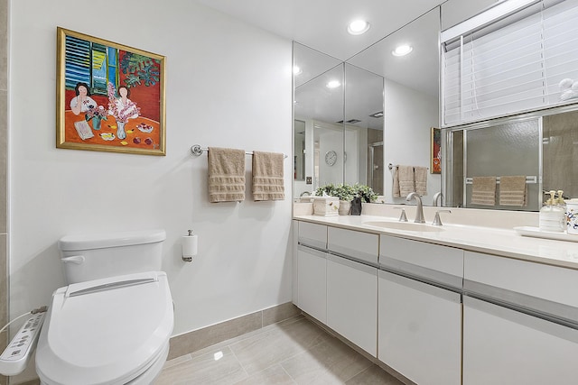 bathroom featuring tile patterned floors, vanity, toilet, and a shower with shower door