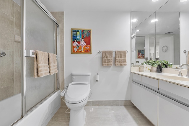 full bathroom featuring shower / bath combination with glass door, tile patterned flooring, vanity, and toilet