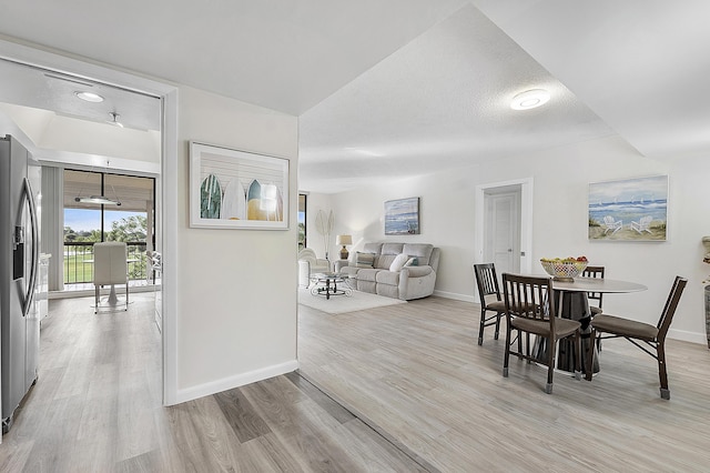 dining room with light hardwood / wood-style floors and a textured ceiling