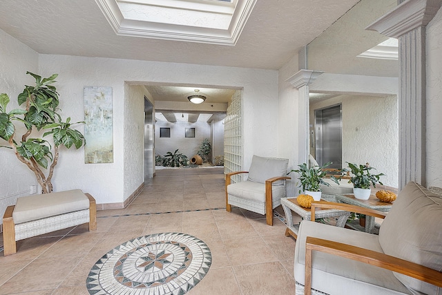 hall featuring light tile patterned floors, a textured ceiling, and a skylight