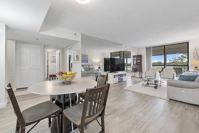 dining space featuring a textured ceiling, light wood-type flooring, and ceiling fan