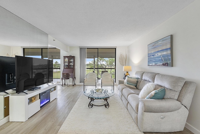 living room with a textured ceiling and light hardwood / wood-style floors