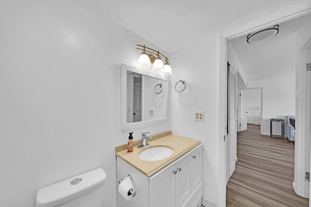 bathroom featuring vanity, hardwood / wood-style flooring, and toilet