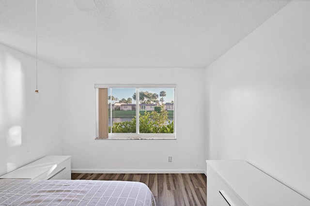 bedroom featuring dark hardwood / wood-style floors and a textured ceiling