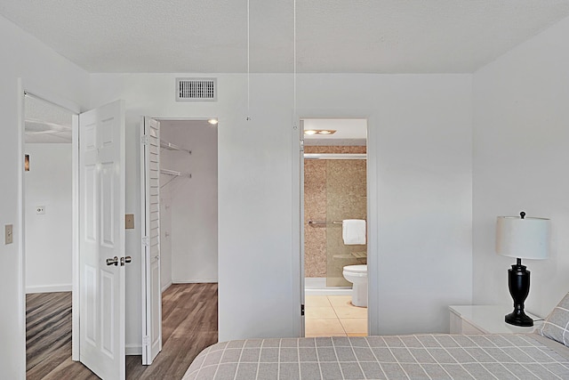 bedroom featuring ceiling fan, dark hardwood / wood-style flooring, connected bathroom, and a closet