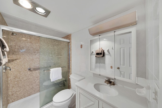 bathroom featuring vanity, an enclosed shower, and toilet