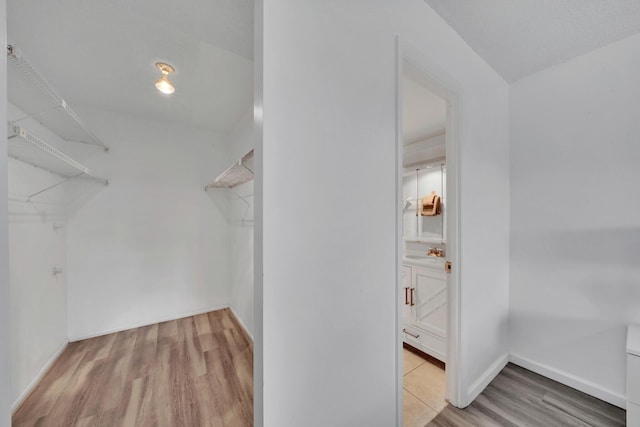 walk in closet featuring sink and light hardwood / wood-style flooring