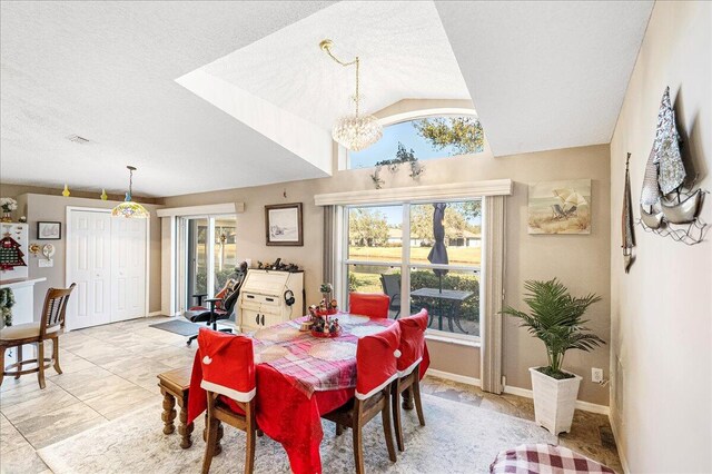 tiled dining area featuring a chandelier, a textured ceiling, lofted ceiling, and a healthy amount of sunlight