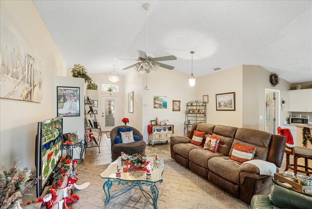 living room featuring a textured ceiling, ceiling fan, and lofted ceiling