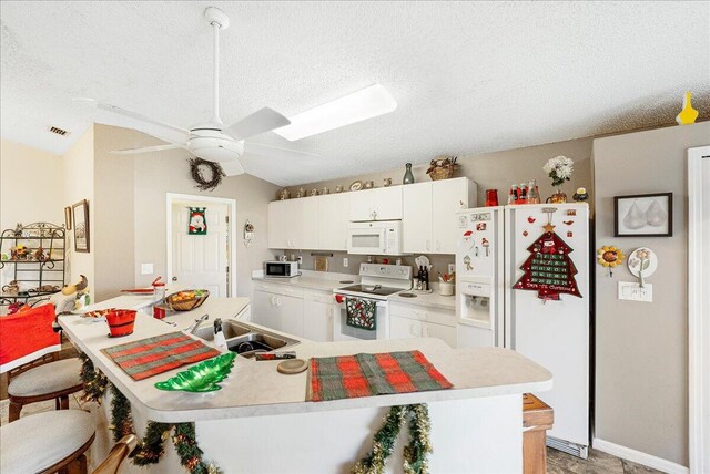 kitchen featuring ceiling fan, sink, vaulted ceiling, white appliances, and white cabinets