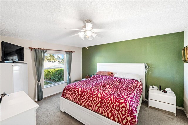 bedroom with carpet, a textured ceiling, and ceiling fan