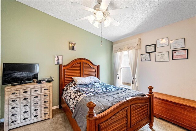 bedroom featuring vaulted ceiling, ceiling fan, light colored carpet, and a textured ceiling