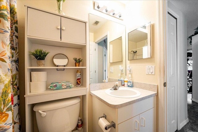 bathroom with a shower with curtain, vanity, and toilet