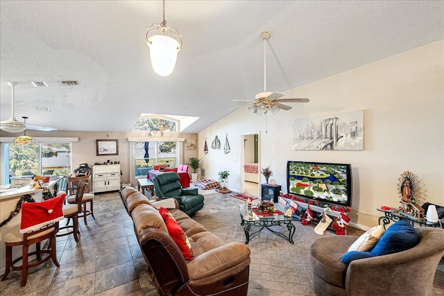 living room featuring a textured ceiling, ceiling fan, and lofted ceiling