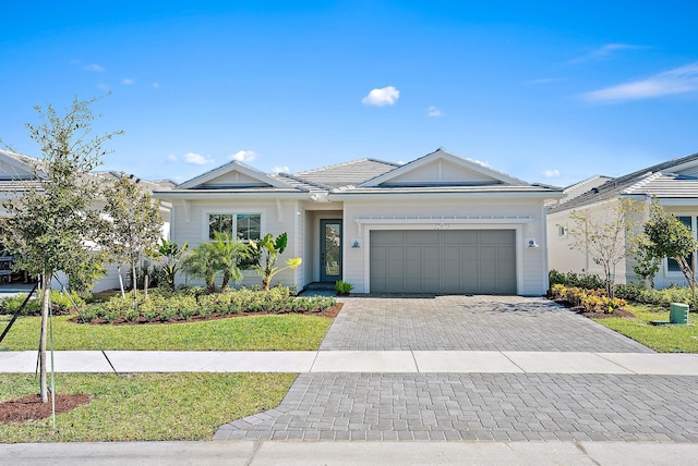 view of front of property with a garage and a front lawn