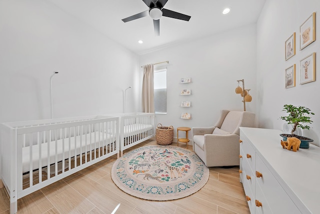 bedroom with ceiling fan and a crib