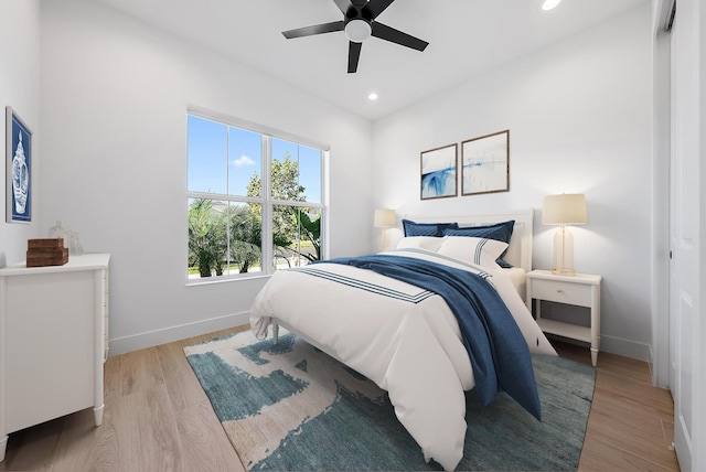 bedroom featuring light wood-type flooring, ceiling fan, and a closet