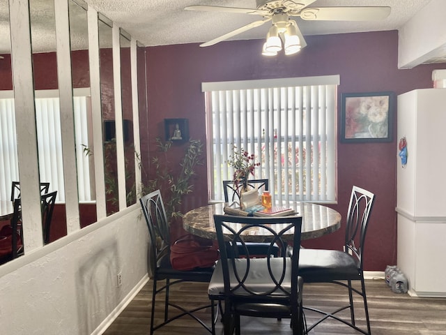 dining space featuring a textured ceiling, ceiling fan, and dark hardwood / wood-style floors