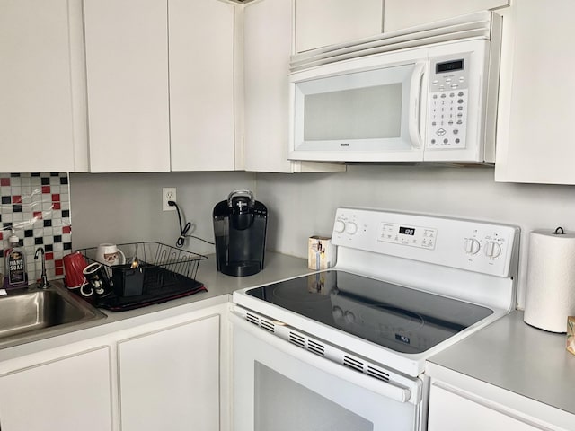 kitchen with white cabinets, decorative backsplash, white appliances, and sink