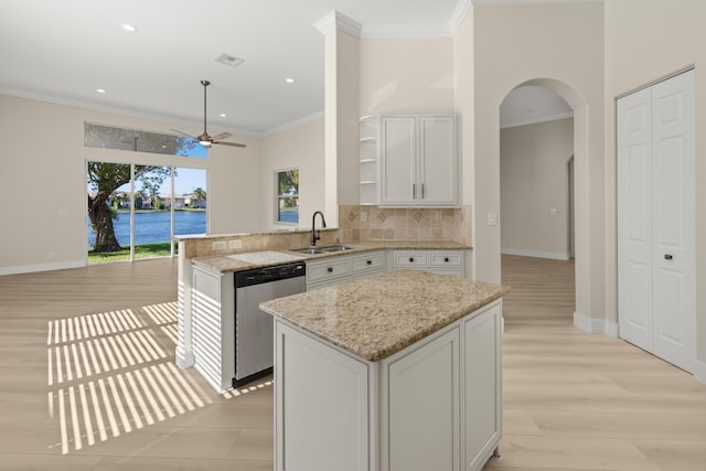 kitchen featuring stainless steel dishwasher, a center island, white cabinets, and sink