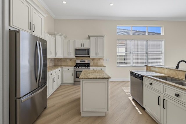 kitchen with a center island, light wood-type flooring, crown molding, and appliances with stainless steel finishes