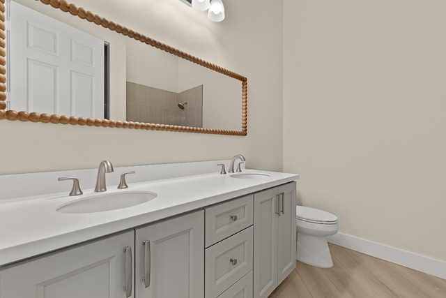 bathroom featuring a shower, vanity, hardwood / wood-style flooring, and toilet