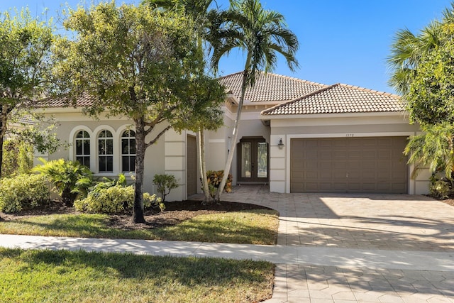 mediterranean / spanish house featuring a garage and french doors