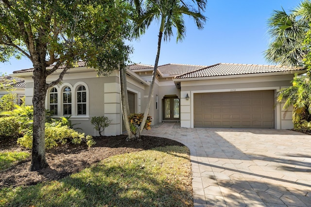 mediterranean / spanish home with a garage and french doors