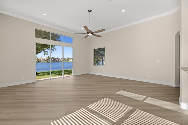 spare room featuring crown molding, light hardwood / wood-style flooring, a water view, and ceiling fan