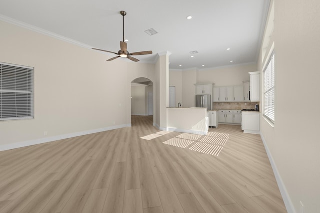 unfurnished living room featuring ceiling fan, light hardwood / wood-style flooring, and ornamental molding