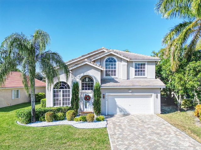 mediterranean / spanish home featuring a garage and a front yard