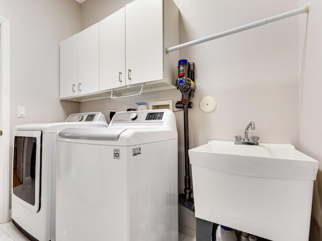 clothes washing area with sink, cabinets, and washing machine and clothes dryer