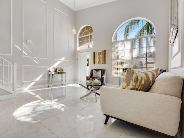 sitting room featuring a towering ceiling and ornamental molding