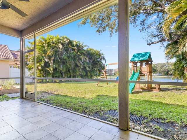 unfurnished sunroom with a water view and ceiling fan