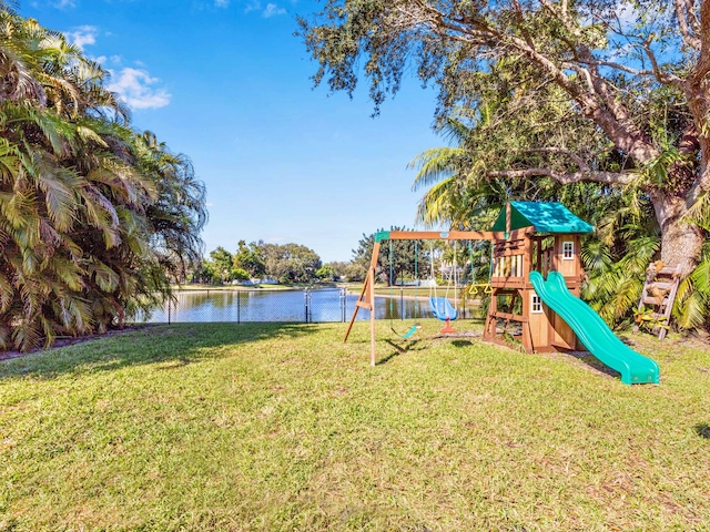 view of playground with a water view and a lawn