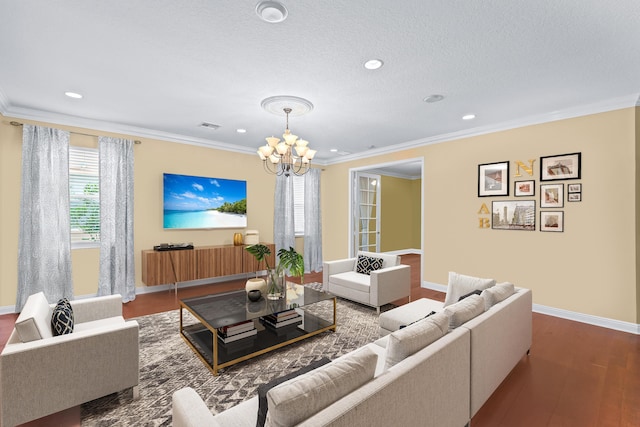 living room with hardwood / wood-style floors, ornamental molding, and a chandelier