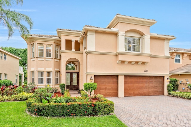 mediterranean / spanish-style house featuring a garage and french doors