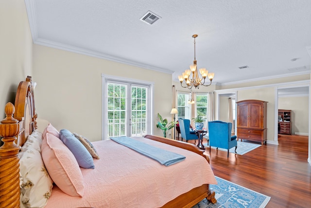 bedroom featuring a textured ceiling, dark hardwood / wood-style floors, ornamental molding, and a notable chandelier